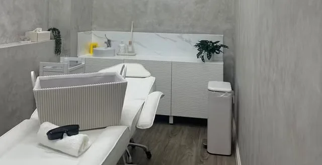 The treatment bed with towel and protective glasses beside the studio cabinets